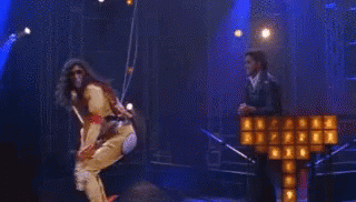 A Woman Is Hanging From A Rope In Front Of A Cross That Is On Fire . GIF
