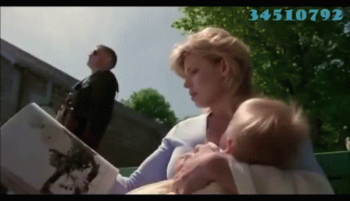 A Woman Is Holding A Baby And Reading A Book With The Number 34510792 On The Bottom Right GIF