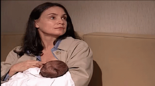 A Woman Is Holding A Baby In Her Arms GIF