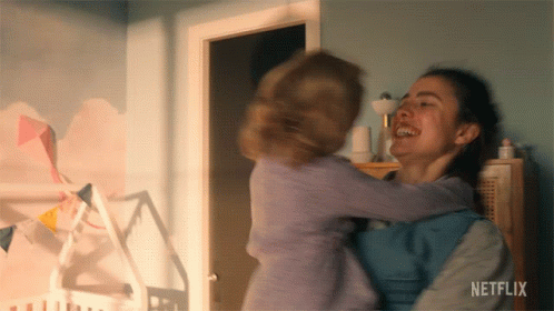 A Woman Is Holding A Baby In Her Arms With Netflix Written On The Bottom Of The Screen GIF