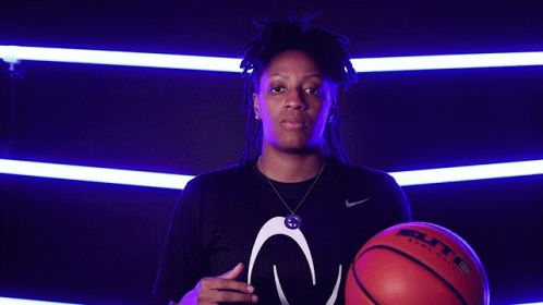 A Woman Is Holding A Baden Basketball In Her Hand GIF