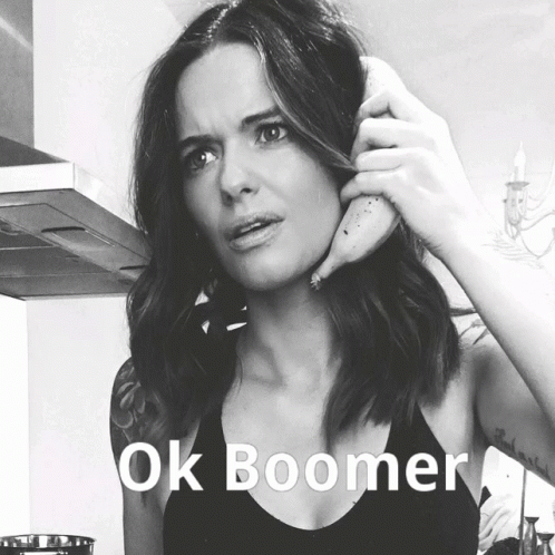 A Woman Is Holding A Banana To Her Ear With The Words Ok Boomer Written Below Her GIF