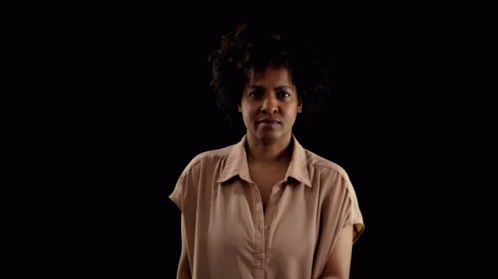 A Woman Is Holding A Bible In Front Of Her Face GIF