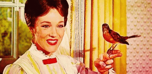 A Woman Is Holding A Bird In Her Hand . GIF