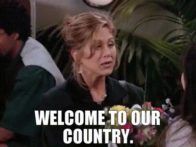 A Woman Is Holding A Bouquet Of Flowers And Says Welcome To Our Country GIF