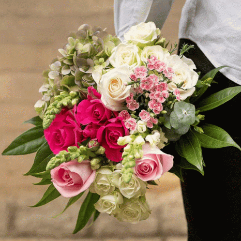 A Woman Is Holding A Bouquet Of Pink And White Roses GIF