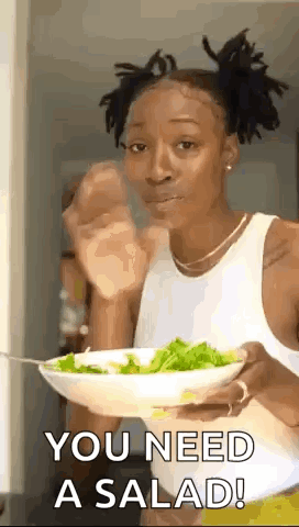 A Woman Is Holding A Bowl Of Salad And Eating It With A Fork . GIF