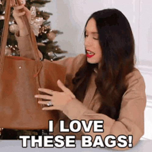 A Woman Is Holding A Brown Tote Bag And Saying I Love These Bags . GIF