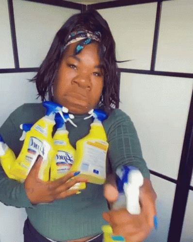 A Woman Is Holding A Bunch Of Clorox Spray Bottles In Her Hands GIF