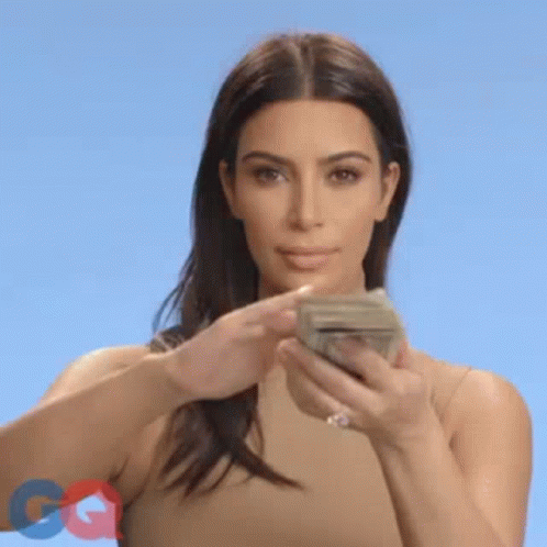 A Woman Is Holding A Bunch Of Money In Her Hands And Throwing It In The Air . GIF
