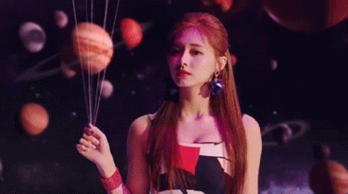 A Woman Is Holding A Bunch Of Planets In Her Hands In Front Of A Planetarium . GIF