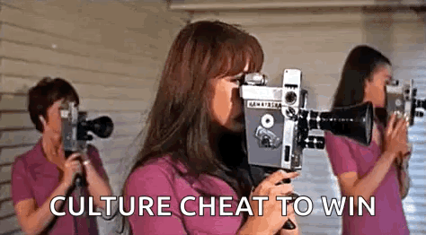 A Woman Is Holding A Camera In Front Of Her Face While Two Other Women Are Holding Cameras In Front Of Their Eyes . GIF