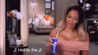 A Woman Is Holding A Can Of Soda Through A Straw In Her Hand . GIF