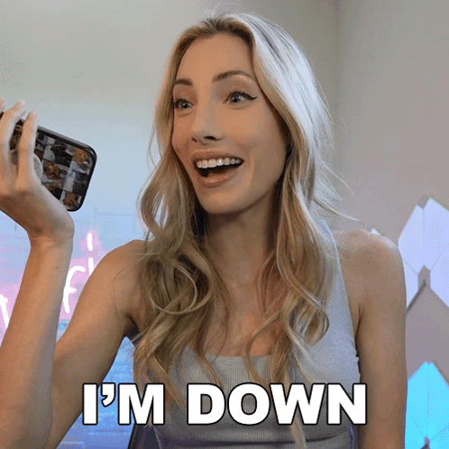 A Woman Is Holding A Cell Phone And Says " I 'M Down " In White Letters GIF