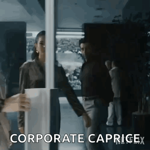 A Woman Is Holding A Cup Of Coffee While Standing Next To A Man In A Dark Room . GIF