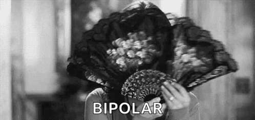 A Woman Is Holding A Fan In Front Of Her Face And The Word Bipolar Is Written Above Her . GIF