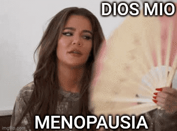 A Woman Is Holding A Fan In Her Hand With The Words `` Dios Mio Menopausia '' Written On It . GIF
