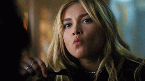 A Woman Is Holding A Fork In Her Hand And Making A Funny Face GIF