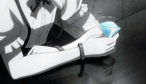 A Woman Is Holding A Glass Of Blue Liquid In Her Hand GIF