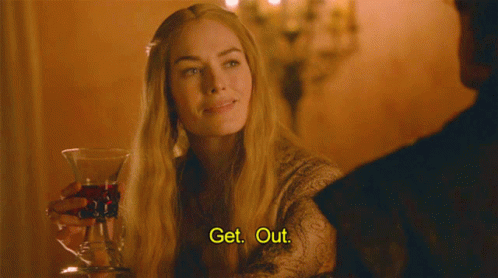 A Woman Is Holding A Glass Of Wine And Saying Get Out GIF