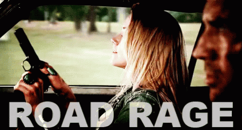 A Woman Is Holding A Gun In A Car With The Word Road Rage Written Above Her GIF