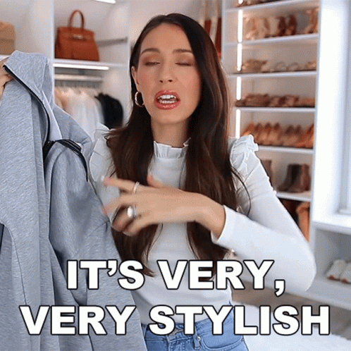 a woman is holding a jacket and says it 's very stylish