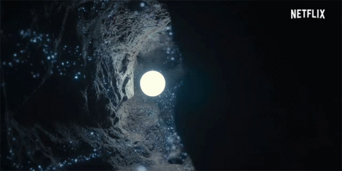 A Woman Is Holding A Light In A Dark Cave With A Netflix Logo In The Background GIF