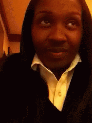 A Woman Is Holding A Lollipop In Her Hand GIF