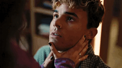 A Woman Is Holding A Man 'S Neck And Looking At Him . GIF