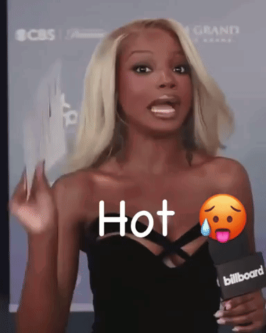 A Woman Is Holding A Microphone That Says Hot GIF