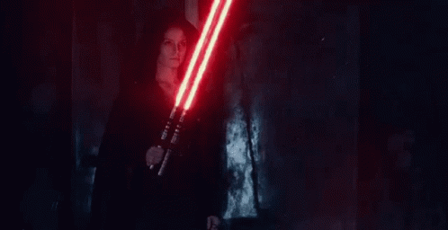 A Woman Is Holding A Pair Of Red Lightsabers In Her Hands . GIF
