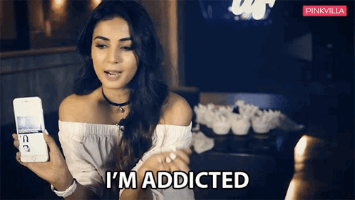 A Woman Is Holding A Phone And Says I 'M Addicted GIF