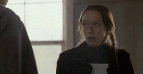 A Woman Is Holding A Piece Of Paper And Looking Up At A Man . GIF