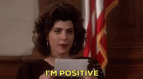 A Woman Is Holding A Piece Of Paper And Says I 'M Positive GIF