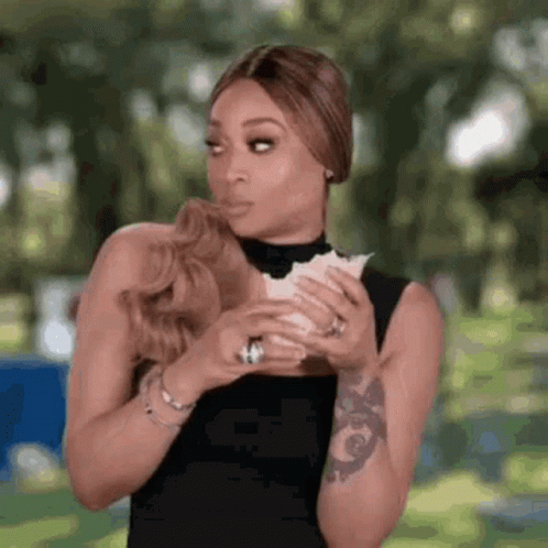 A Woman Is Holding A Piece Of Paper In Her Hands . GIF