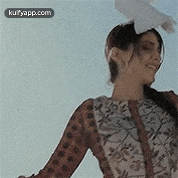 A Woman Is Holding A Pigeon On Her Head . GIF