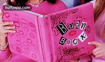 A Woman Is Holding A Pink Book Called The Burn Book GIF