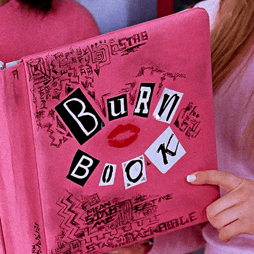 A Woman Is Holding A Pink Burn Book With A Kiss On It GIF