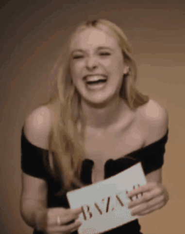 A Woman Is Holding A Sign That Says Bazaar GIF