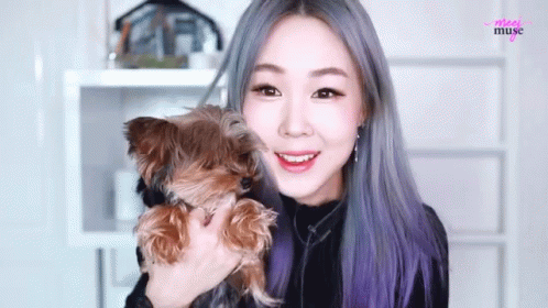 A Woman Is Holding A Small Brown Dog In Her Arms And The Word Muse Is On The Bottom GIF