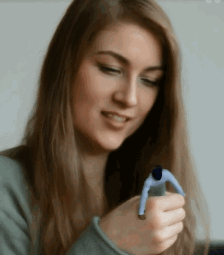 A Woman Is Holding A Small Man In Her Hands GIF