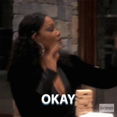 A Woman Is Holding A Stack Of Jenga Blocks And Says " Okay " GIF