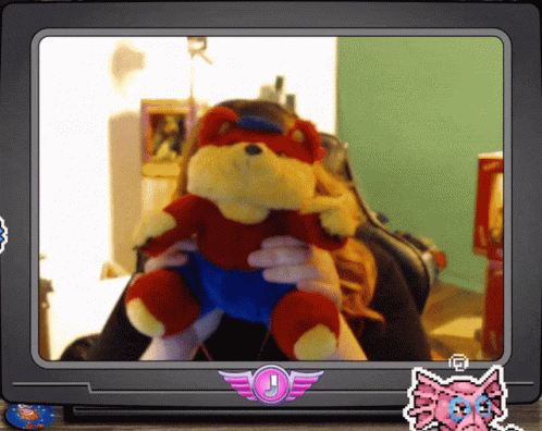 A Woman Is Holding A Stuffed Animal In Front Of A Tv Screen With A Sticker That Says J GIF