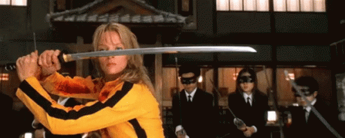 A Woman Is Holding A Sword In Front Of A Group Of Men GIF