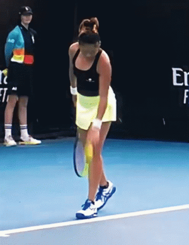 A Woman Is Holding A Tennis Racket On A Blue Court GIF