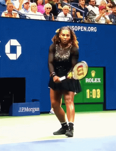 A Woman Is Holding A Tennis Racquet In Front Of A Scoreboard That Says Rolex GIF