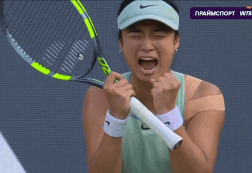 A Woman Is Holding A Tennis Racquet In Front Of A Screen That Says Primesport Wta GIF