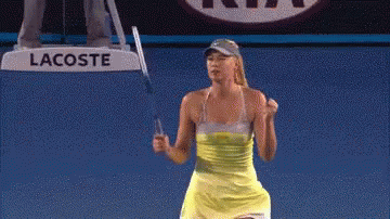 A Woman Is Holding A Tennis Racquet In Front Of A Sign That Says Lacoste GIF