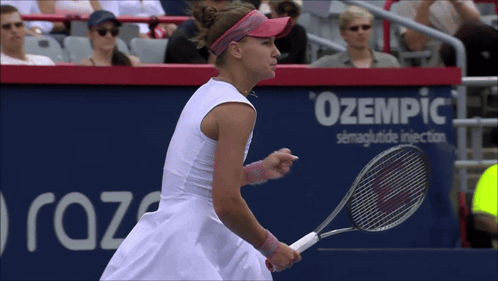 A Woman Is Holding A Tennis Racquet In Front Of A Sign That Says Ozempic GIF