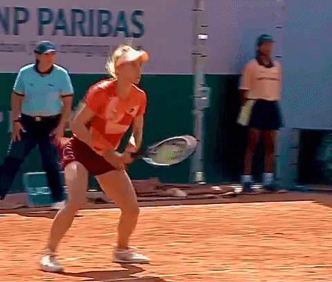 A Woman Is Holding A Tennis Racquet On A Court In Front Of A Sign That Says Np Paribas GIF